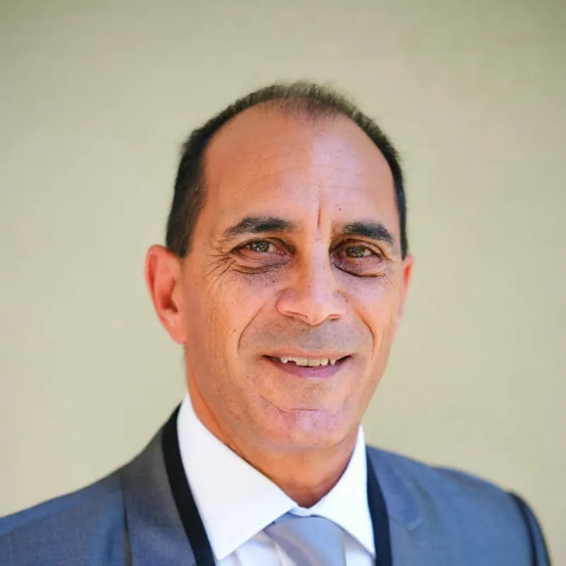Studio headshot of Horacio Danovich in a gray suit and light blue tie